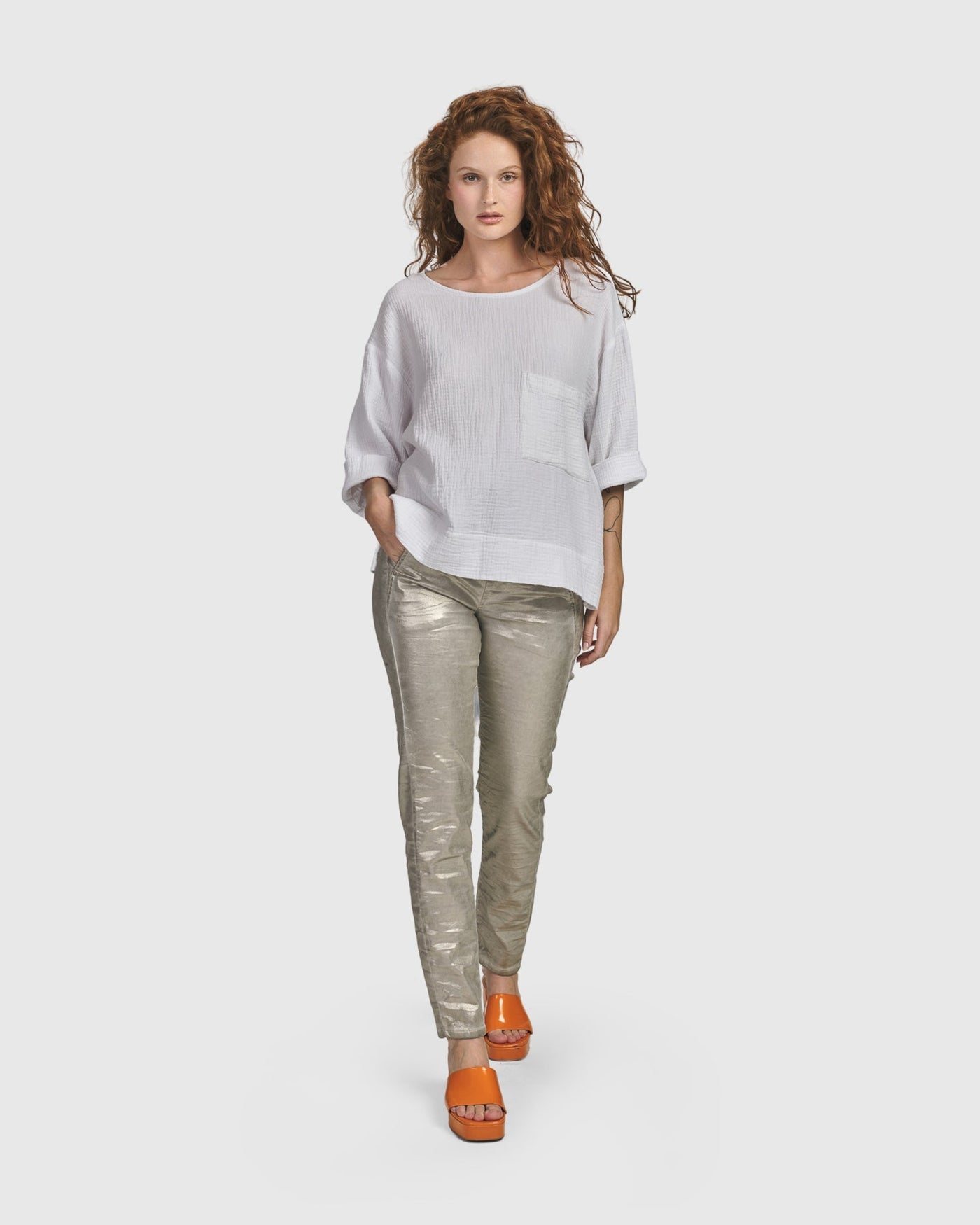 A woman wearing a white shirt and Iconic Stretch Jeans with a drawstring stretch waist by ALEMBIKA.