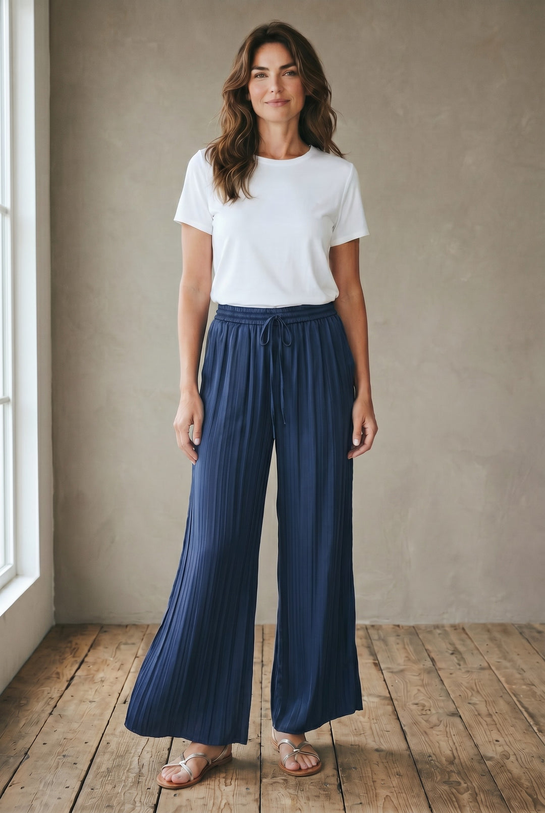 Just Perfect Collection Online blue satin pleated palazzo pants with drawstring waist and raw hem worn by a model.