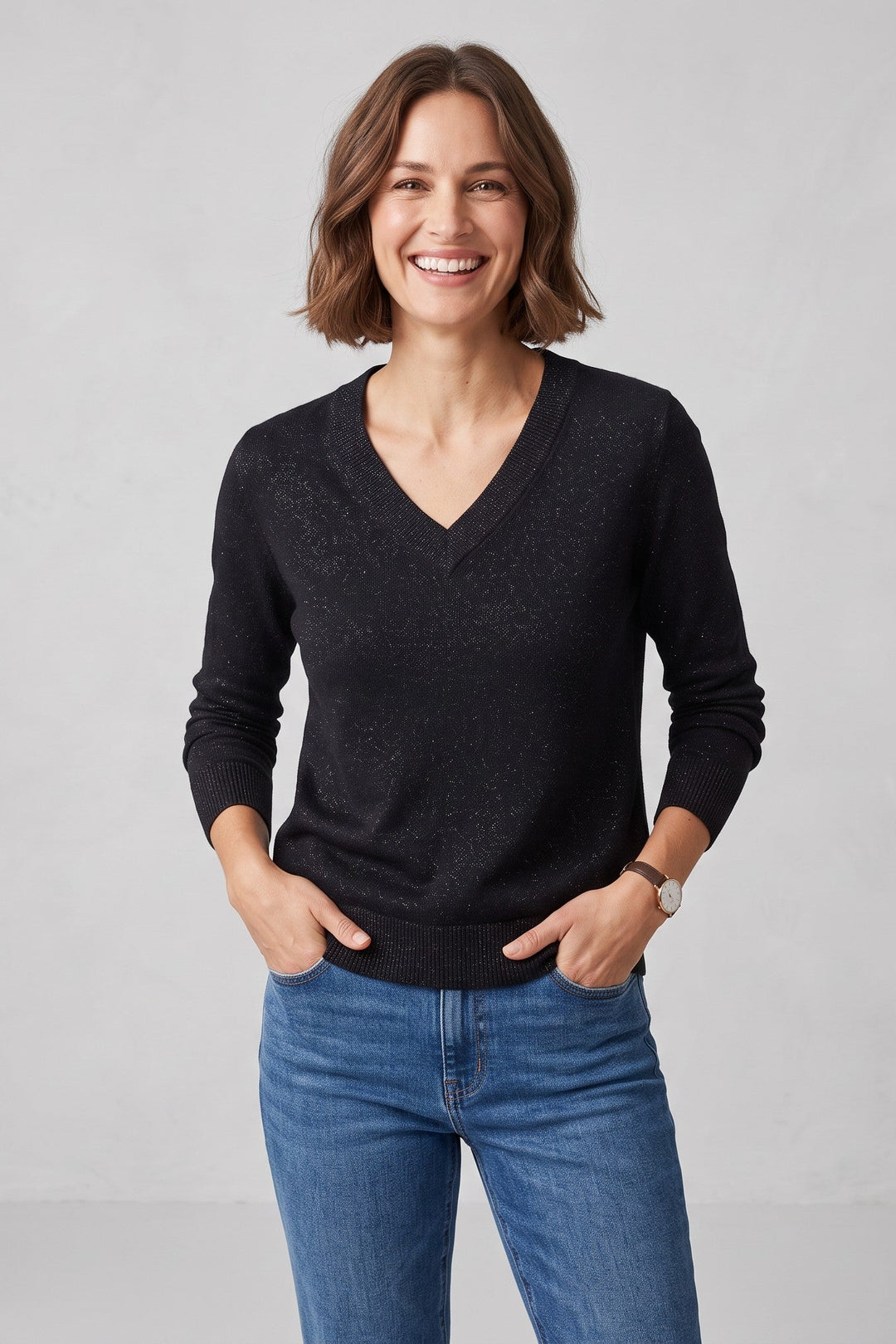 Woman wearing a black Just Perfect Collection Online cashmere V-neck sweater with subtle shimmering lurex accents.
