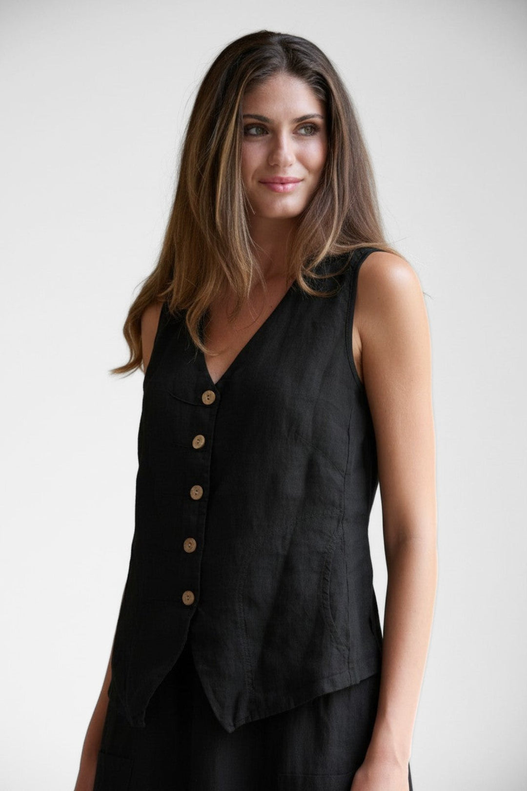 Model wearing a Just Perfect Collection Online black linen tuck vest with button-down front and tailored fit.