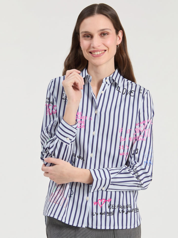 Model wearing a Just Perfect Collection Online blue striped cotton shirt with playful doodles and handwritten text.