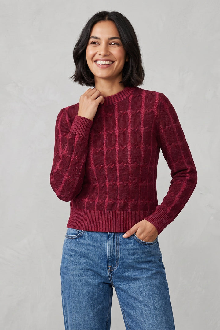Woman wearing a Just Perfect Collection Online burgundy 100% cashmere cable knit crew neck sweater with blue jeans.