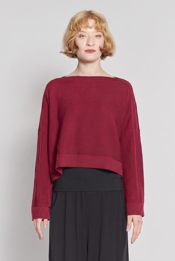Model wearing a cherry red Just Perfect Collection Online Georgia boatneck sweater with a cropped boxy fit