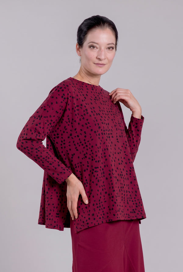 Model wearing Just Perfect Collection Online Karen cherry red swing top with black dot print and 3/4 sleeves