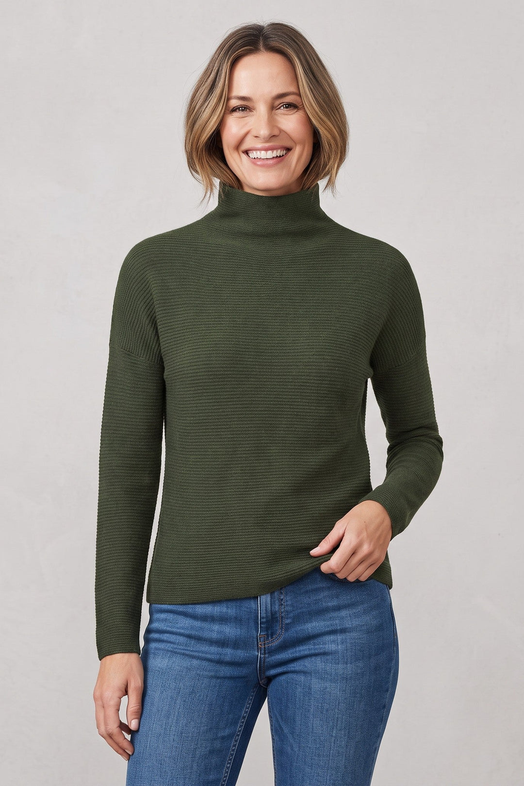 Woman wearing a Just Perfect Collection Online dark green cashmere funnel neck sweater with a textured knit finish.