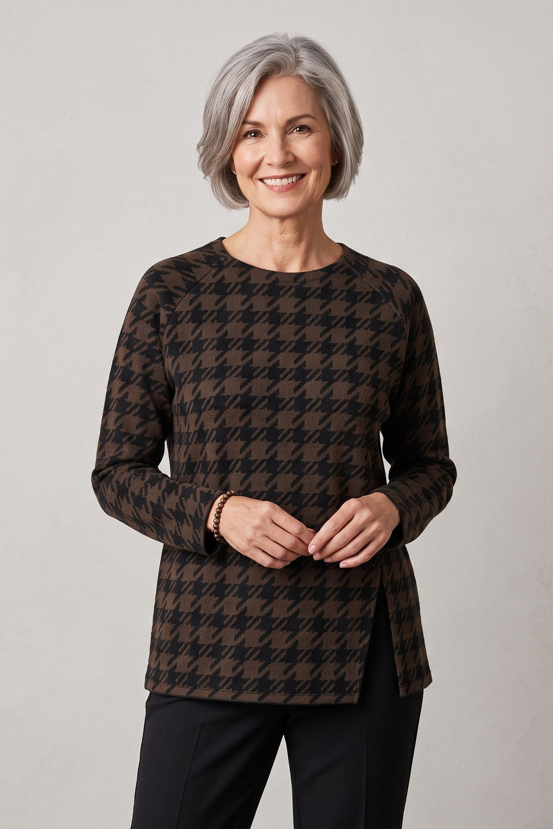 Just Perfect Collection Online oversized black and brown houndstooth top with a front slit worn by a smiling woman