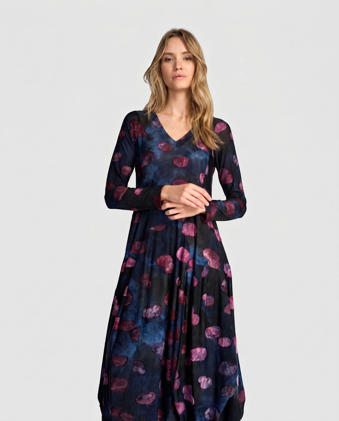 Model wearing a Just Perfect Collection Online midnight blue V-neck dress with purple abstract print and bubble hem.