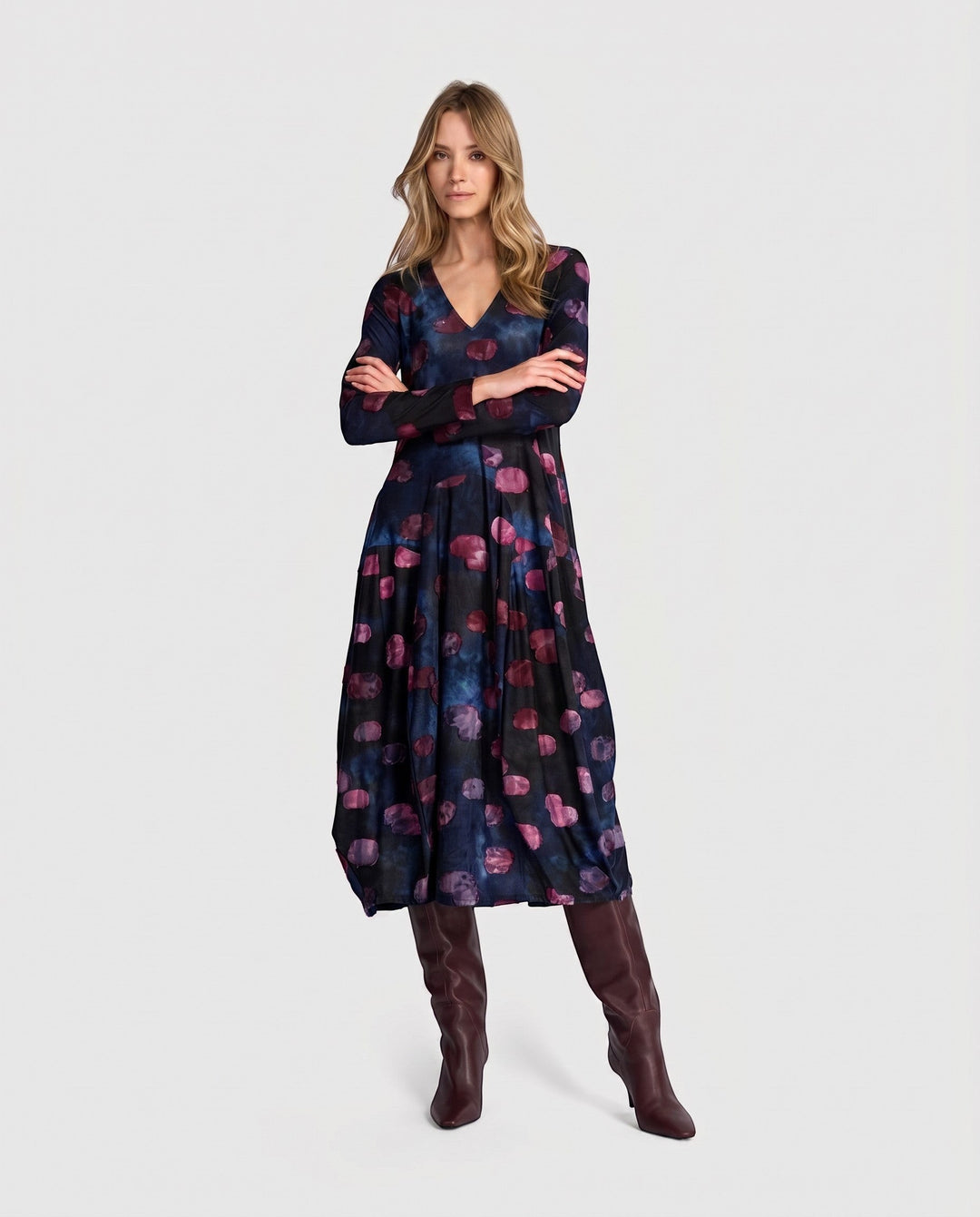 Model wearing a Just Perfect Collection Online midnight V-neck dress with a bubble hem and purple abstract print