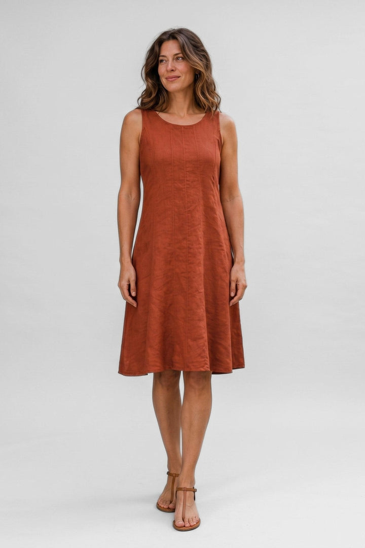 Woman wearing a Just Perfect Collection Online rust linen sleeveless seamed dress with a round neckline.